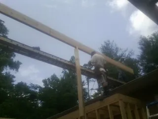 Carpenter setting a ridge beam over a new addition frame — Ice Dam Removal by Roofing Brothers in Ware Shoals